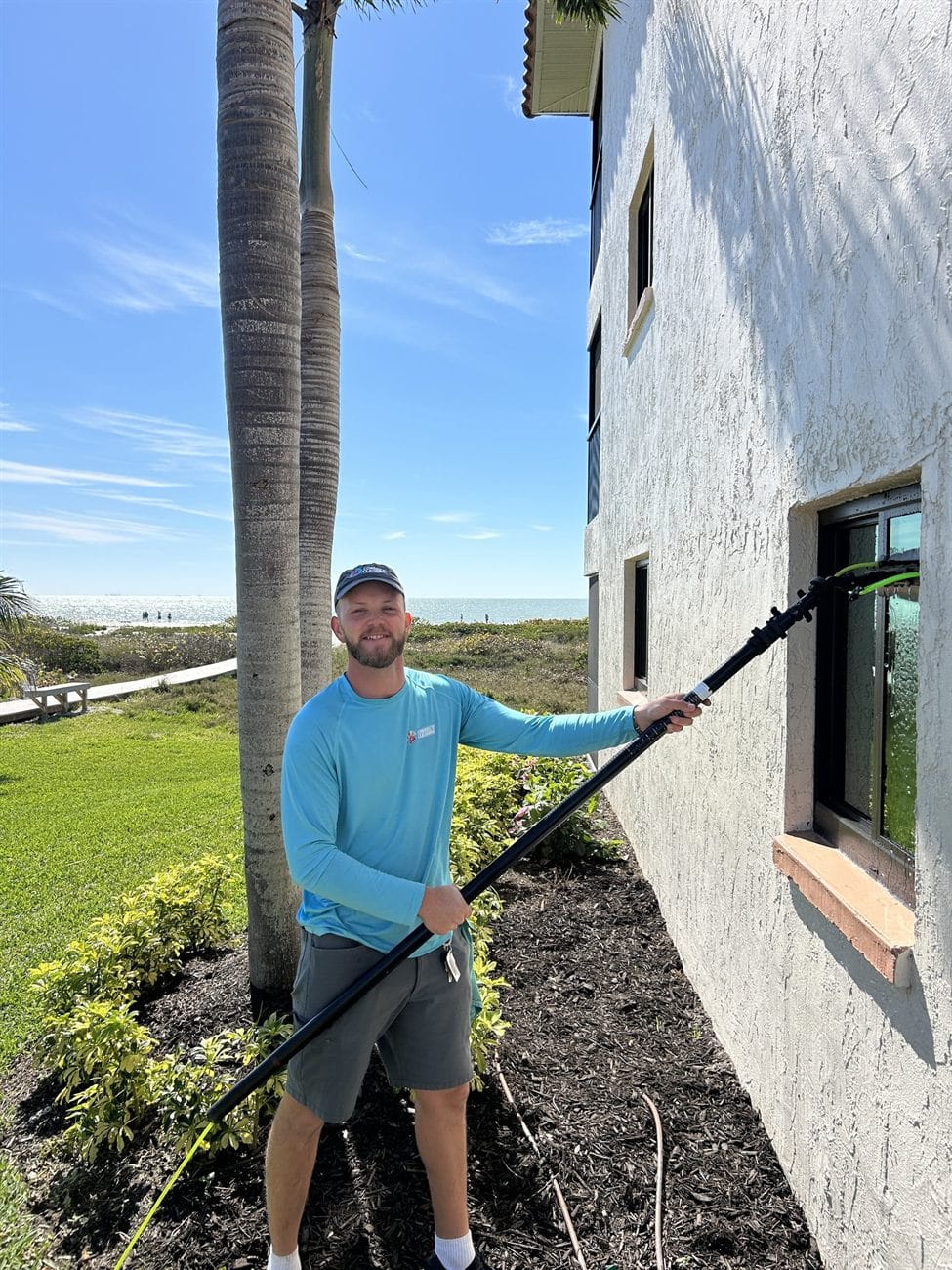 Connect Cleaning technician soft washing the exterior of a Southwest Florida commercial building