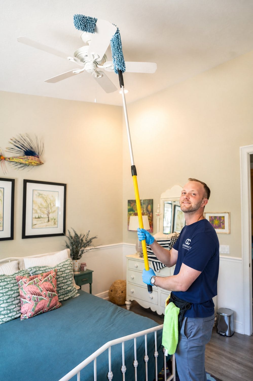 Connect Cleaning team member dusting a ceiling fan in a Southwest Florida bedroom